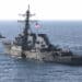 Before 9/11: The Day Terror Struck the USS Cole and Changed the U.S. Military 3 001029-M-0557M-011
The USS Cole (DDG 67) is towed away from the port city of Aden, Yemen, into open sea by the Military Sealift Command ocean-going tug USNS Catawba (T-ATF 168) on Oct. 29, 2000. Cole will be placed aboard the Norwegian heavy transport ship M/V Blue Marlin and transported back to the United States for repair. The Arleigh Burke class destroyer was the target of a suspected terrorist attack in the port of Aden on Oct. 12, 2000, during a scheduled refueling. The attack killed 17 crew members and injured 39 others. DoD photo by Sgt. Don L. Maes, U.S. Marine Corps. (Released)
